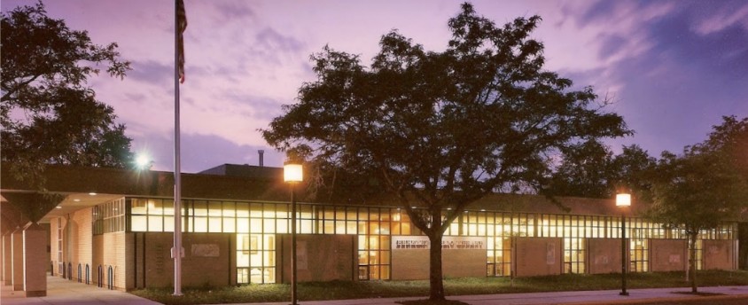 Library building at sunset with trees in foreground.