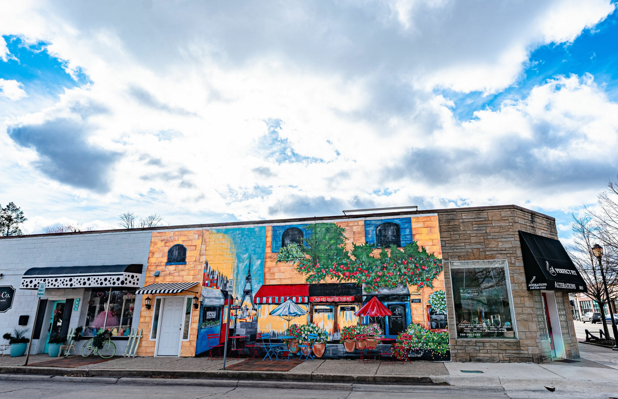 Colorful mural on building under cloudy sky.