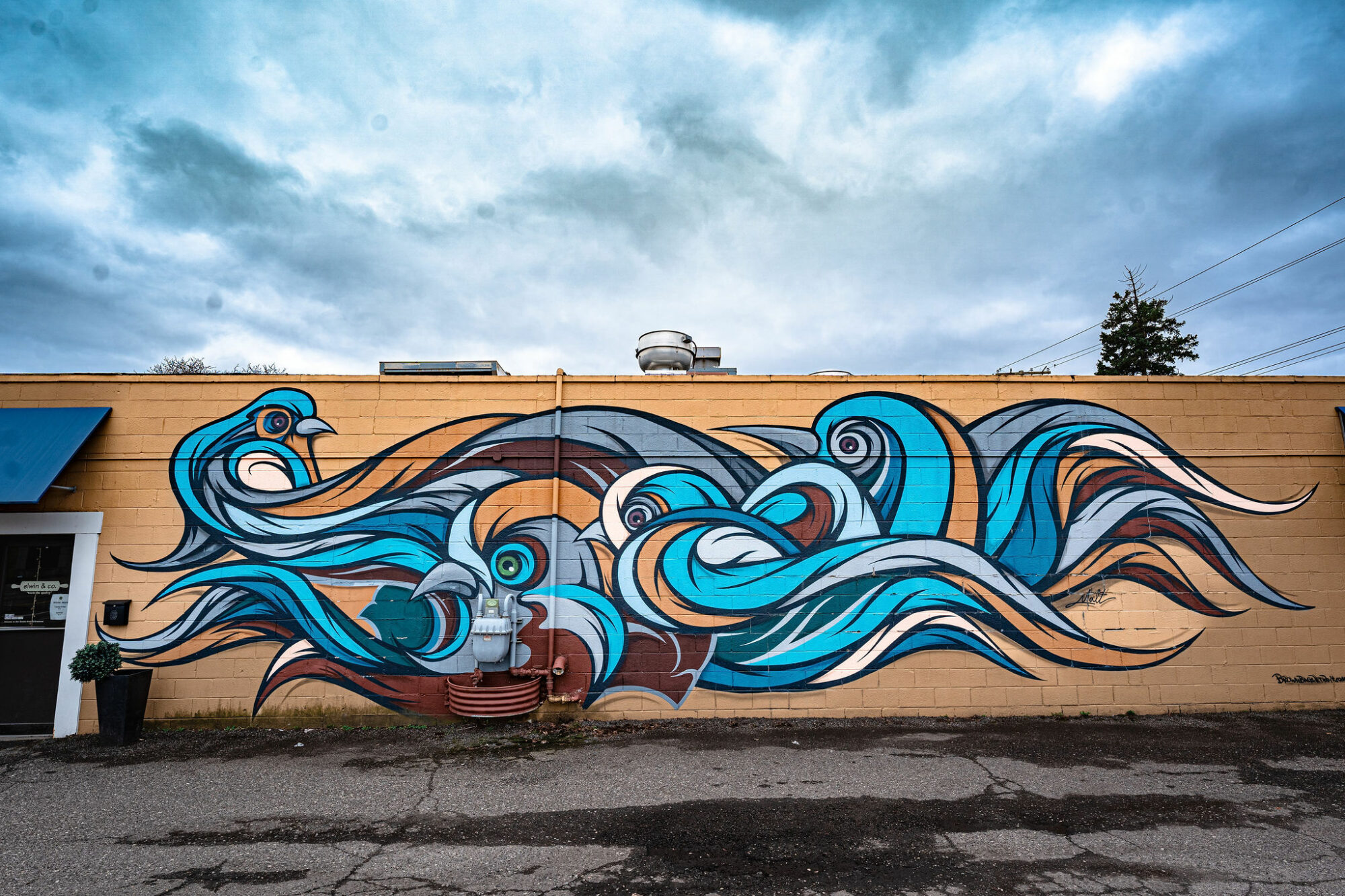 Colorful mural of swirling ocean waves on wall.