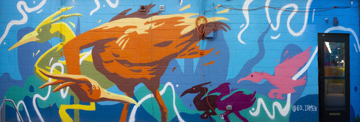 Colorful bird mural on urban wall.