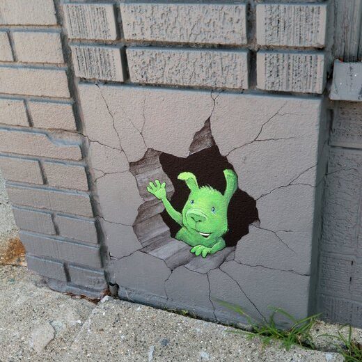 Green creature peeking through wall hole mural
