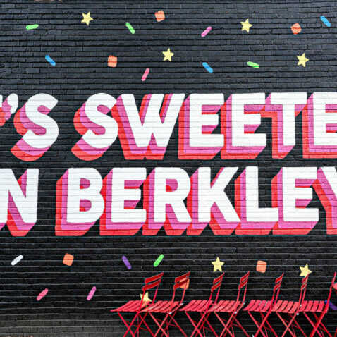 Colorful mural with confetti and red chairs.