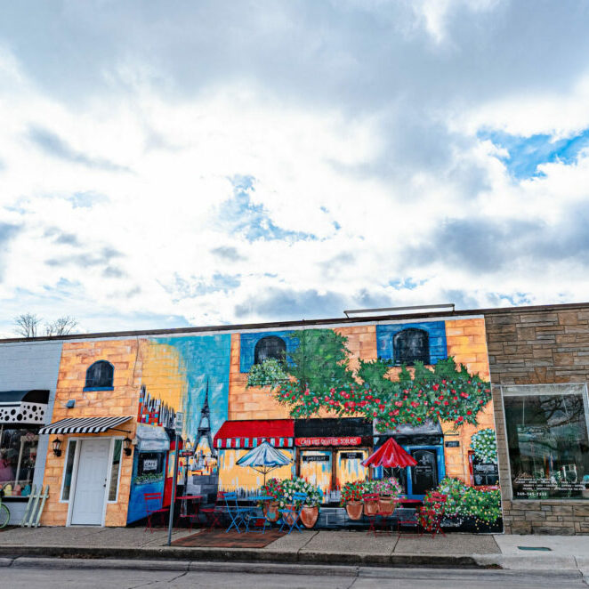 Colorful mural on building under cloudy sky.