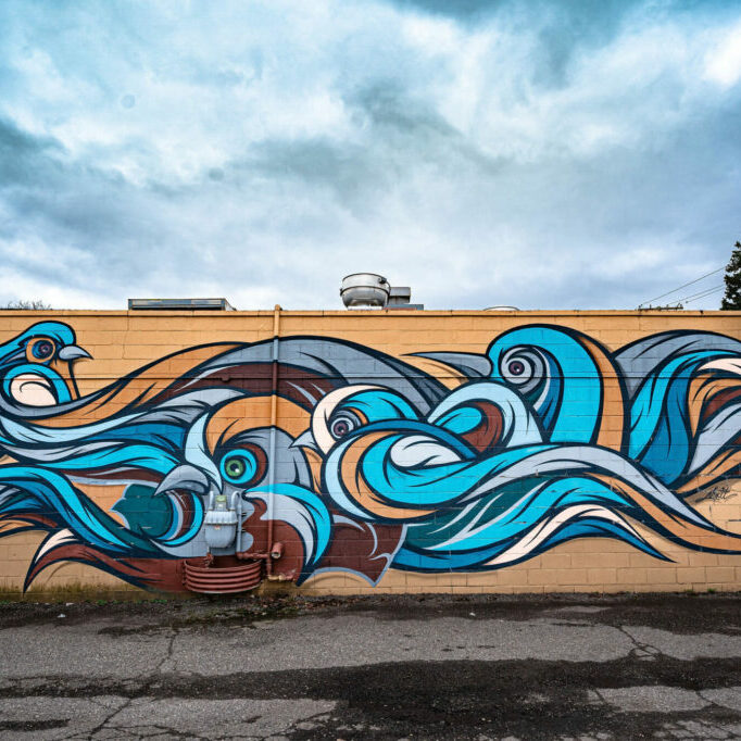 Colorful mural of swirling ocean waves on wall.