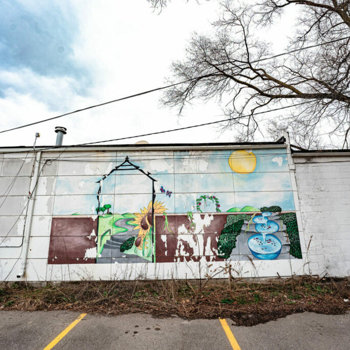 Colorful mural with sunflowers on concrete wall.