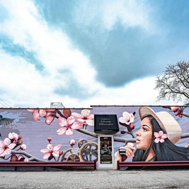 Colorful mural with flowers and a woman in hat.